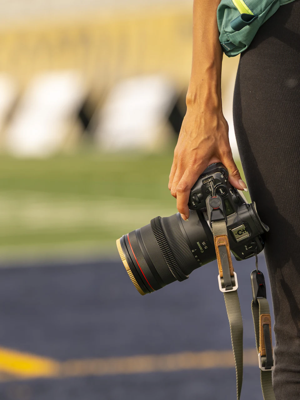 A photographer's camera held at the side of a field