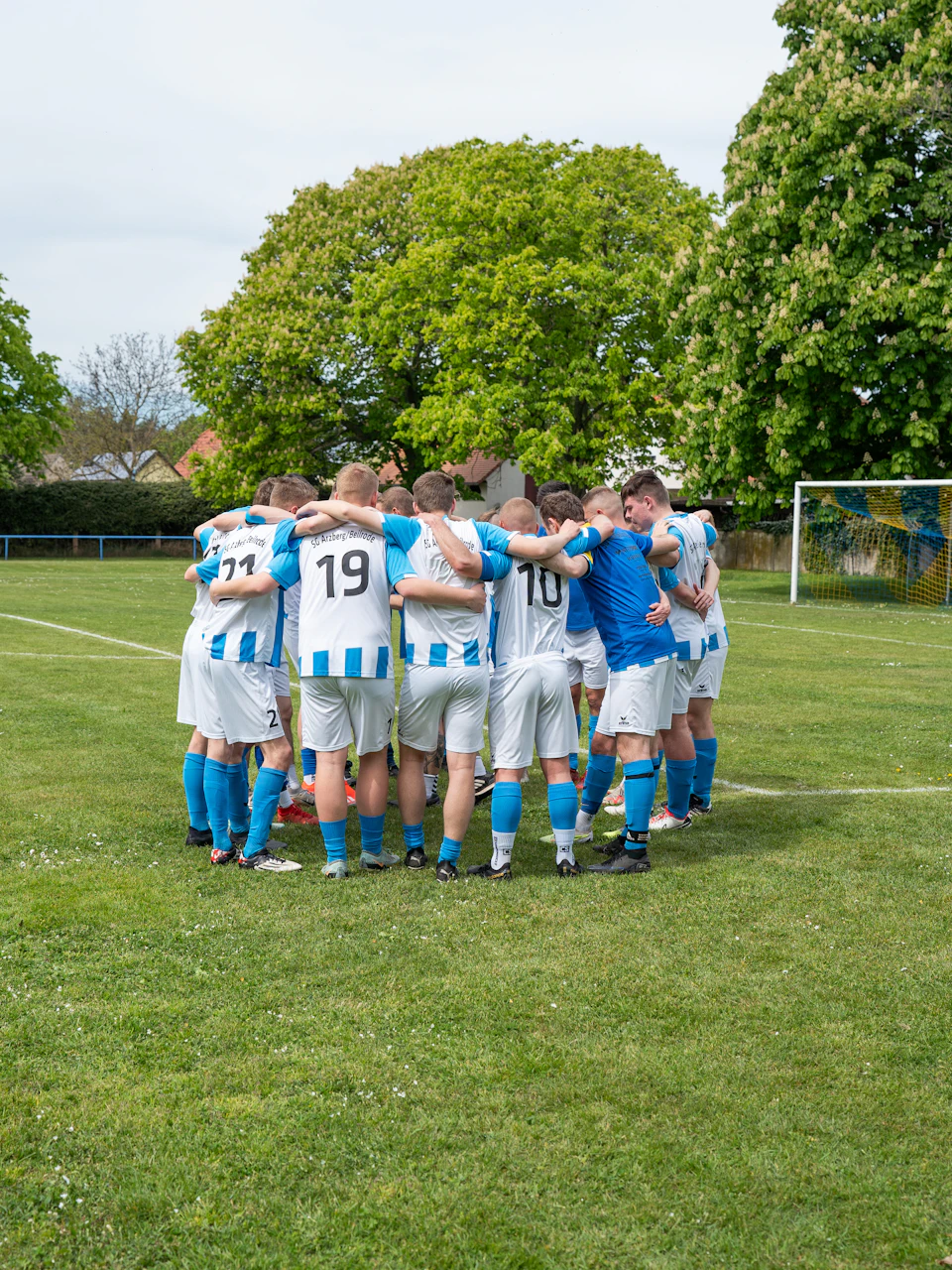 A soccer team huddled before kickoff