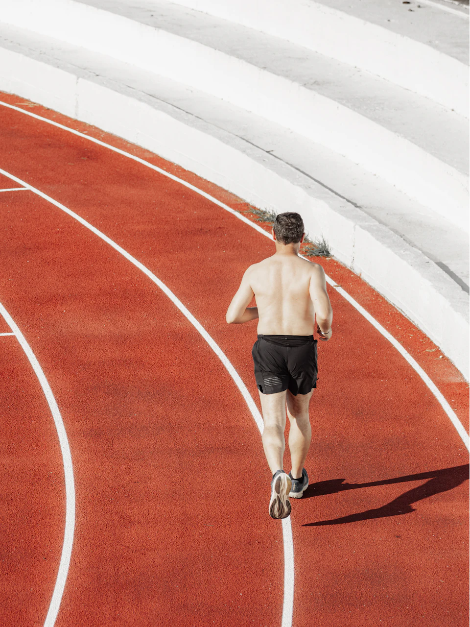 A runner on the curve of a red track